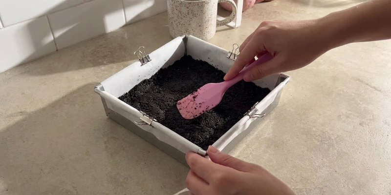 Presionando la base de galleta Oreo en el molde