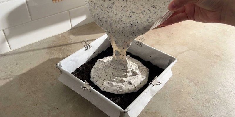 Relleno cremoso vertido sobre la base de Oreo en el molde
