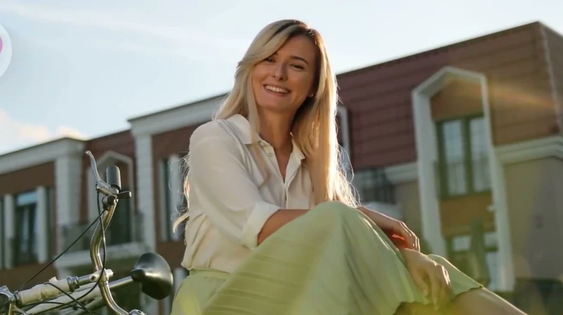 Mujer sentada al aire libre con media sonrisa